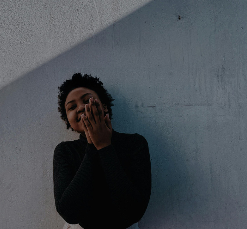 Woman leaning against a wall.
